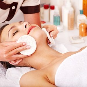 Young woman getting facial  massage in beauty spa.